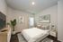 Cozy bedroom with modern decor, featuring a comfortable bed, stylish artwork, and indoor plant.