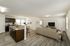 Contemporary living room with open-concept kitchen and sleek wooden flooring.