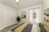 Cozy bedroom with stylish decor, featuring a comfortable bed, lush plant, and modern artwork.