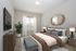 Stylish bedroom with modern decor, featuring a cozy bed, decorative mirror, and elegant furnishings.
