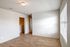 Bright, airy room with wooden flooring, neutral walls, and a large window inviting natural light.