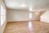 Spacious open-plan living area with elegant wood flooring, large windows for natural light, and modern light fixtures.