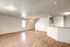 Spacious open-plan living area with elegant wooden flooring and a modern kitchen bar for entertaining.