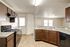 Modern kitchen with sleek dark wood cabinets, spacious countertops, and bright natural lighting.
