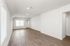Bright and airy open-concept living area with elegant wood flooring and large window offering natural light.