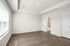 Bright, spacious room with elegant wood flooring and abundant natural light, featuring access to an adjacent modern bathroom.