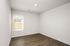 Bright and airy room with elegant wood flooring and a large window inviting natural light.