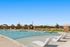 Inviting outdoor pool area featuring luxurious sun loungers and vibrant orange umbrellas, perfect for relaxation and leisure.