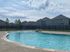 Inviting outdoor swimming pool with clear blue water, surrounded by a secure fence and scenic suburban homes, perfect for relaxation and leisure.