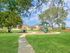 Inviting community playground surrounded by lush greenery and a charming residential neighborhood.