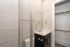 Elegant bathroom with sleek vanity, modern fixtures, and spacious walk-in closet.