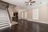Modern open-concept living area with sleek hardwood floors, elegant staircase, and a stylish kitchen in view, creating a spacious and inviting home.