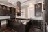 Elegant modern kitchen with dark wood cabinets, sleek marble countertops, and stainless steel appliances, perfect for gourmet cooking.