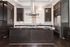 Modern kitchen with sleek dark wood cabinetry, marble countertops, and stainless steel appliances.