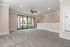 Bright and spacious living room with elegant recessed lighting, large glass doors, and a modern ceiling fan.