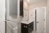 Elegant bathroom with modern fixtures, sleek dark vanity, and glass shower enclosure.