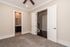 Bright and inviting room with plush carpet, ceiling fan, and access to a modern bathroom showcasing sleek fixtures.