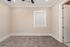 Bright, inviting room featuring soft carpet flooring, a window with blinds, and a ceiling fan for optimal comfort.