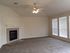 Bright living room with plush carpeting, elegant fireplace, and large windows bringing in natural light.