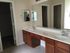 Modern bathroom featuring dual sinks, elegant mirrors, and sleek wooden cabinetry, perfect for a stylish and functional home.