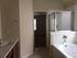 Elegant bathroom with a modern glass shower and luxurious soaking tub, featuring a sleek vanity design.