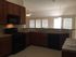 Modern kitchen with sleek appliances, warm wooden cabinets, and ample natural light showcasing an inviting cooking space.