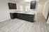 Modern kitchen featuring dark cabinets, sleek countertops, and open concept design with natural light.