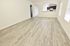 Bright and spacious open-concept living area with elegant wood flooring and modern kitchen view.