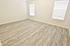 Inviting room with elegant light wood flooring and abundant natural light through large windows, perfect canvas for your design ideas.