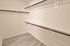 Spacious walk-in closet with sleek shelving and elegant wood flooring, perfect for organizing your wardrobe.