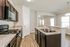 Modern kitchen with sleek dark cabinets, granite countertops, and stainless steel appliances, offering a spacious layout and ample natural light.