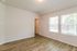 Bright and airy room with large windows, elegant wooden flooring, and freshly painted walls.