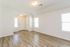 Inviting entryway with elegant wood flooring, abundant natural light, and modern lighting fixtures in a contemporary apartment.