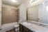 Modern bathroom with a sleek granite countertop, tiled shower, and elegant lighting fixtures.