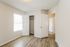 Bright and inviting room featuring elegant wooden flooring, a spacious closet, and ample natural light through a large window.
