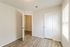 Bright and airy room with elegant wooden flooring, ample natural light, and a modern door design.