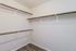 Spacious walk-in closet with elegant wood shelving and modern design, perfect for organized living.