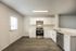 Modern kitchen featuring sleek stainless steel appliances, white cabinetry, and elegant wood flooring with abundant natural light.