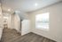 Bright hallway with modern lighting, hardwood flooring, and staircase leading up, adjacent to a sleek bathroom.
