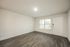 Bright and spacious living room with modern laminate flooring and large window letting in natural light, perfect for cozy gatherings.