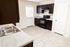 Modern kitchen with dark wood cabinets, sleek countertops, and stainless steel sink, featuring natural light and classy flooring.