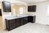 Modern kitchen with sleek dark cabinetry, stylish countertops, and an open layout with natural light.
