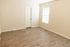 Bright, airy room with sleek wood flooring and a large window allowing natural light to fill the space.