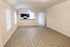 Spacious open living area featuring natural light, wood flooring, and an elegant kitchen with dark cabinetry.