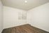 Bright and airy room with modern wood flooring, fresh white walls, and a large window for natural light.