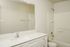 Elegant bathroom with a spacious countertop, large mirror, and pristine bathtub.