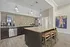 Contemporary kitchen with granite countertops, stainless steel appliances, and elegant pendant lighting. Features a stylish breakfast bar with seating, perfect for entertaining.