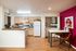 Modern kitchen and dining area with sleek appliances, vibrant accent wall, and stylish decor.