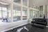 Modern fitness center featuring expansive windows, an array of dumbbells, and a spin bike, offering a bright and invigorating workout space.