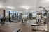 Modern apartment fitness center with state-of-the-art equipment, large windows, and a bright, inviting atmosphere.